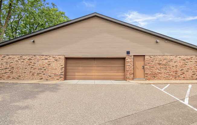 A building with a brown garage door and a brick wall.