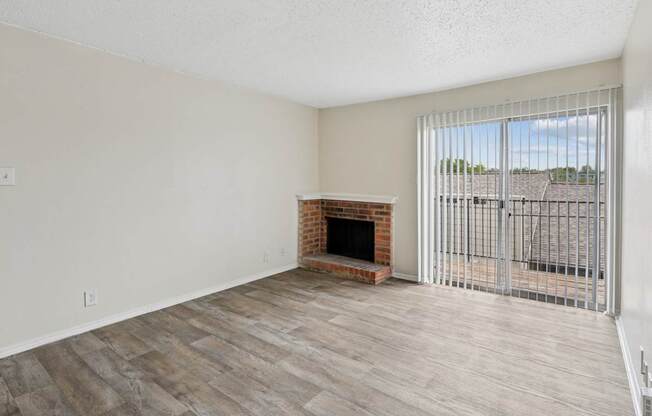 A2 living room with a fireplace and a sliding glass door at Westdale Pointe in Austin, TX