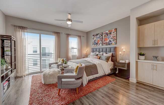 a bedroom with a bed and a chair and a ceiling fan