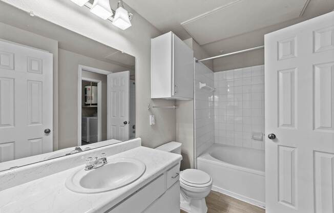 A white bathroom with a sink, toilet, and bathtub.