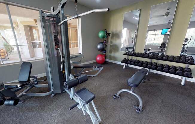 Workout station with weight benches next to free weight area in fitness center