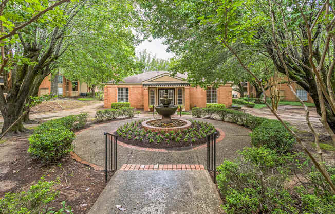 A brick building with a fountain in front of it.