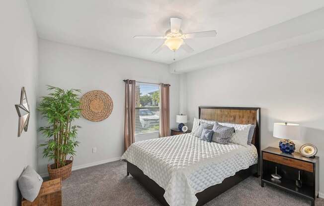 A bedroom with a large bed and a ceiling fan.