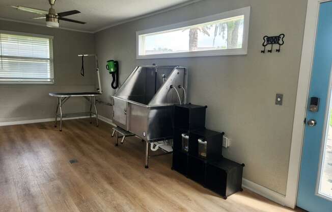 a surgery room with a surgery table and a large silver tub