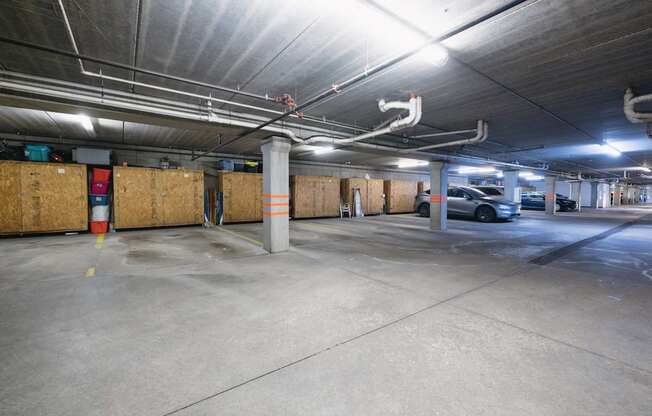 A parking garage with a concrete floor and a concrete ceiling with lights.