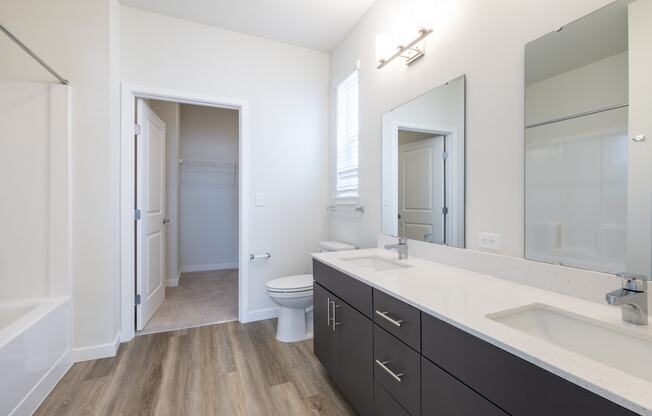 a bathroom with a large mirror and a sink and a toilet