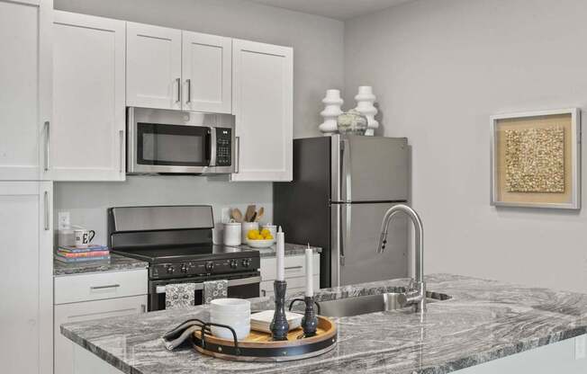 A kitchen with a marble countertop and stainless steel appliances.