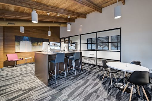 an open office space with tables and chairs and a bar with chairs at Ashford Belmar Apartments, Lakewood, CO 80226