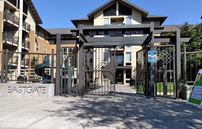 a gate is open in front of a building with a playground in the background