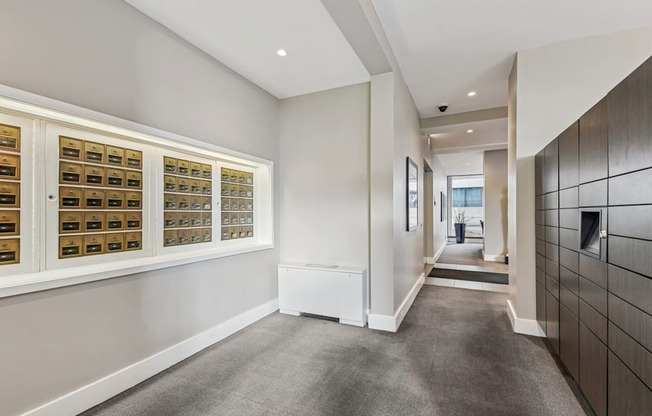 A hallway with a carpeted floor and a wall of lockers on the right.