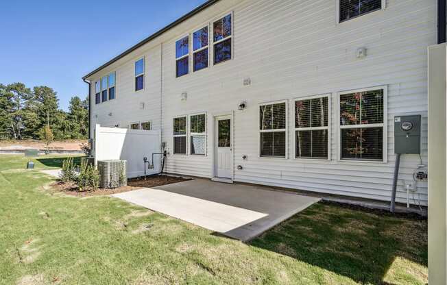 the outside of a white house with a concrete driveway