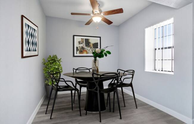 a dining room with a table and chairs and a ceiling fan