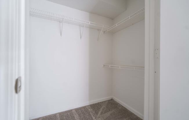 an empty room with white walls and a white closet