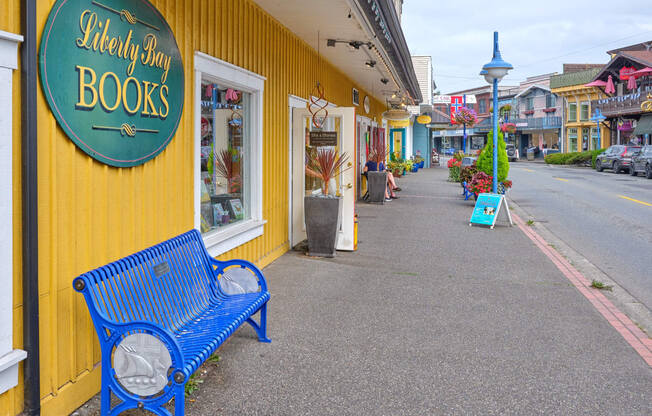 a blue bench in front of a yellow building at Woodcreek, Poulsbo, WA 98370