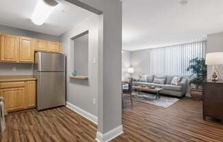 A kitchen with wooden cabinets and a stainless steel refrigerator.