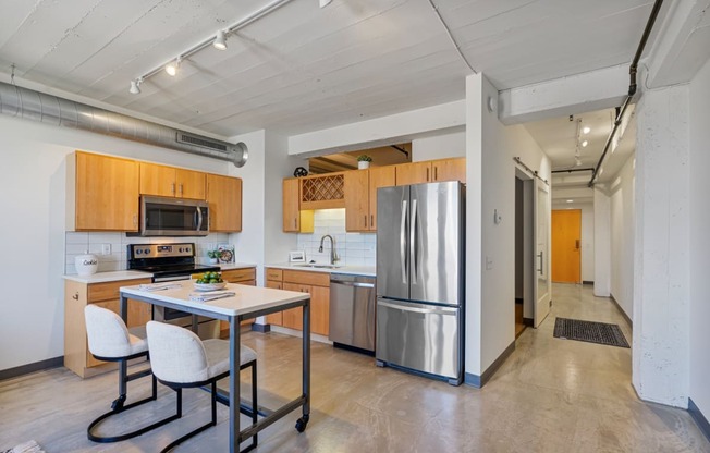 a kitchen with stainless steel appliances and a table with chairs