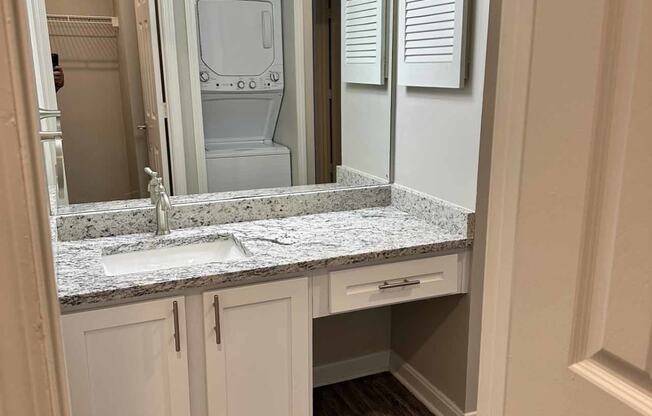 a view of a bathroom with a sink and a washer and dryer