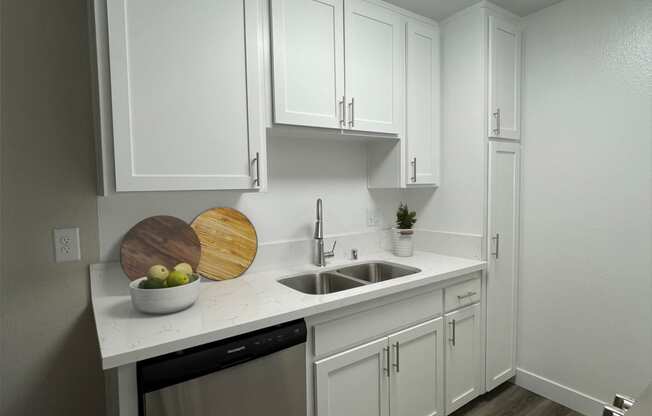 a small kitchen with white cabinets and a sink
