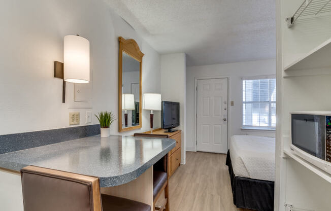 a living room with a kitchen and a bedroom with a bed  at Waterford Studios, Texas, 78758