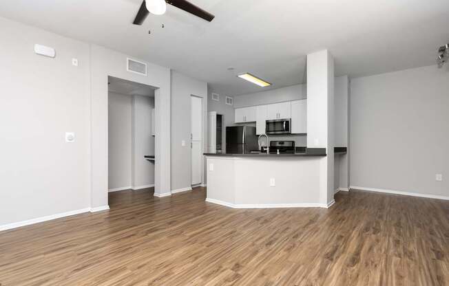 A spacious kitchen with a bar area and wooden flooring.