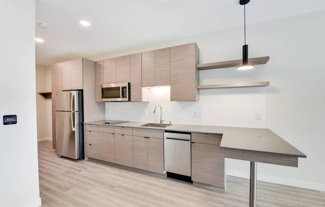 A modern kitchen with a refrigerator, microwave, and a countertop.