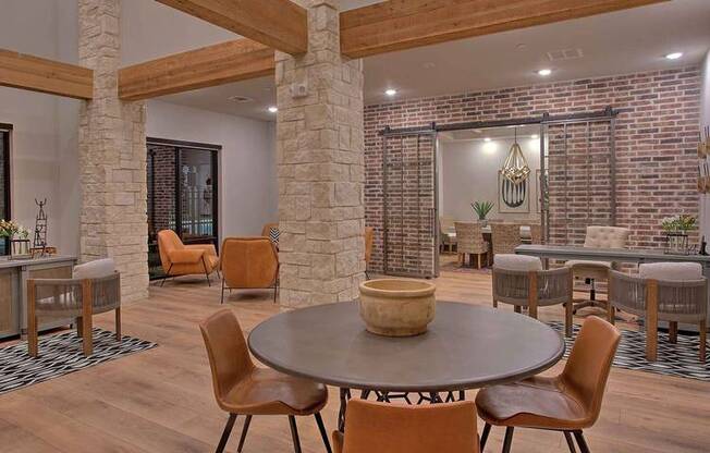 a living room with a table and chairs and a brick wall at Hunters Creek Apartments, Texas