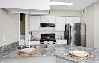 Kitchen with Granite Countertops and a stainless steel refrigerator