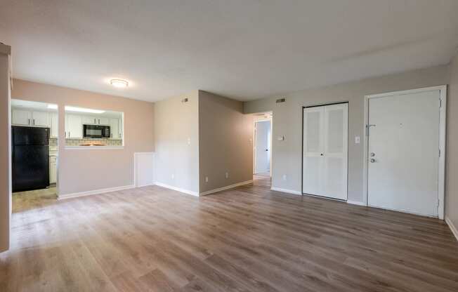 an empty living room with wood floors and white walls