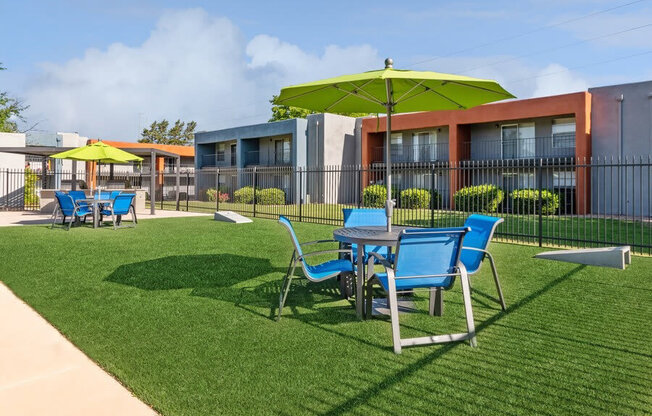 Outdoor Corn Hole Area with Covered Patio Furniture at Indigo Park Apartments in Albuquerque, NM.
