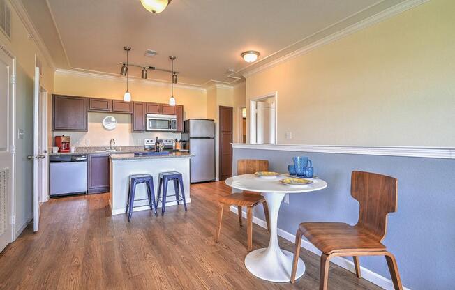 a kitchen with a table and chairs next to a kitchen