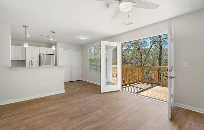 an open living room and kitchen with a sliding glass door to a balcony