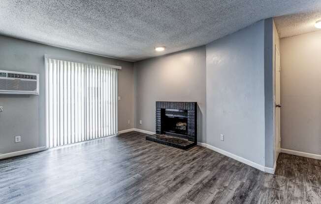 Empty living room with a fireplace and a window  at Union Heights Apartments, Colorado Springs, CO