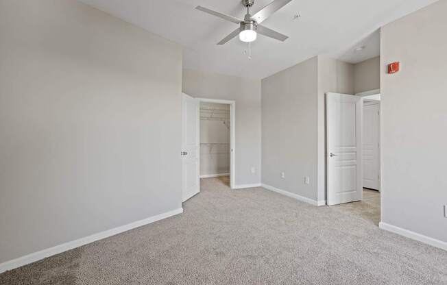 Flatiron West Trade Apartments gray carpeted bedroom with attached balcony
