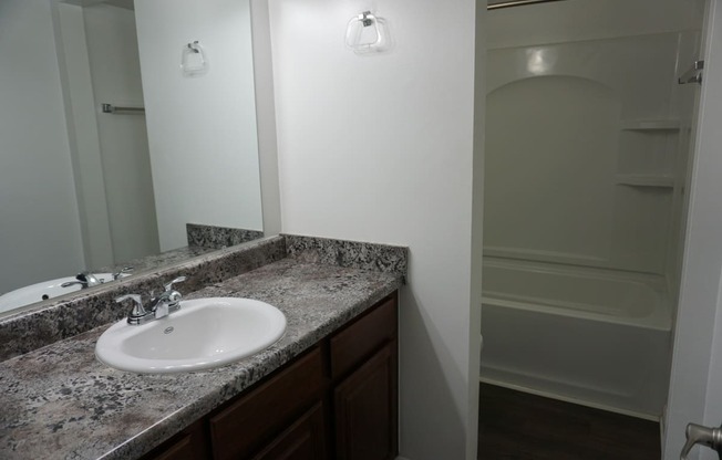 Bathroom with granite countertops at Woodcrest Apartments in Westland, Michigan