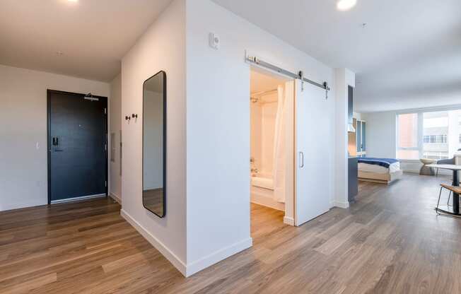a bedroom with white walls and hardwood floors at Marina Square, Bremerton, 98337