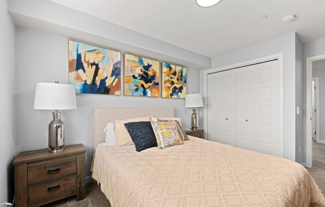 a bedroom with a bed and paintings on the wall