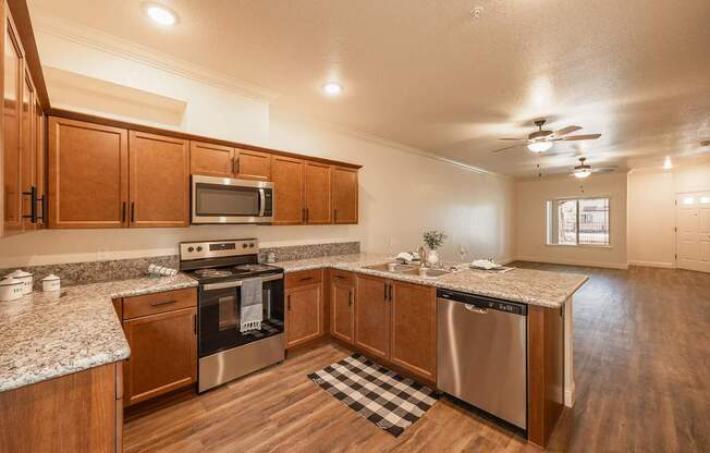 A kitchen with wooden cabinets and a checkered mat on the floor.