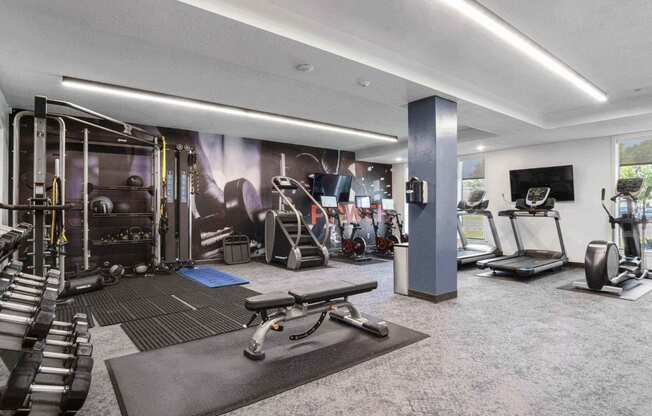 a spacious fitness room with cardio equipment and a flat screen tv at The Flats at Riverwoods, Utah, 84604