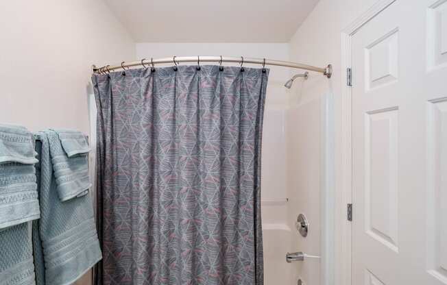 a bathroom with a shower curtain and a white door