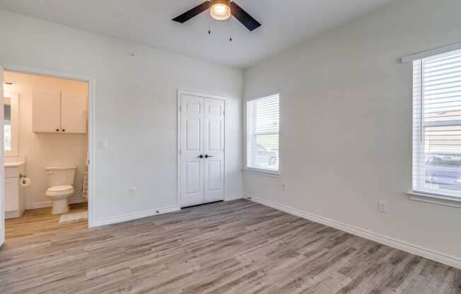 an empty living room with white walls and a ceiling fan