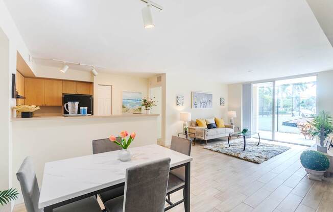 a living room and dining room with a white table and chairs