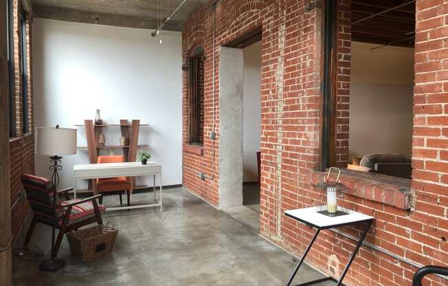 a living room with a brick wall and a table