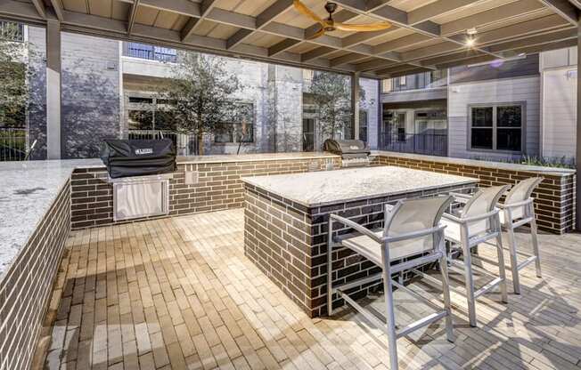 a patio with a bar and a grill at Arise Riverside, Austin, TX 