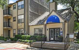 a building with a blue awning and stairs in front of it