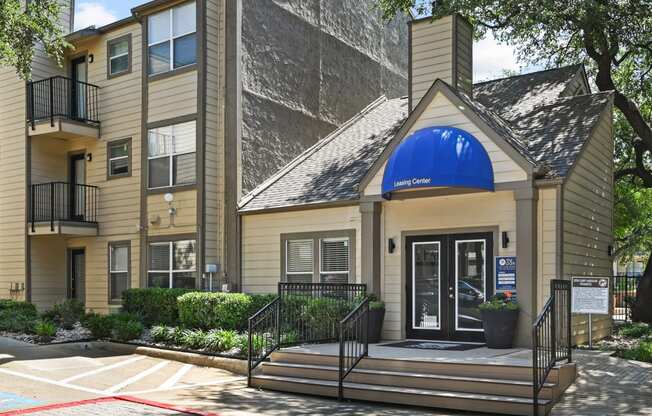 a building with a blue awning and stairs in front of it