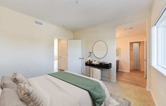 a bedroom with a large bed and a desk with a mirror