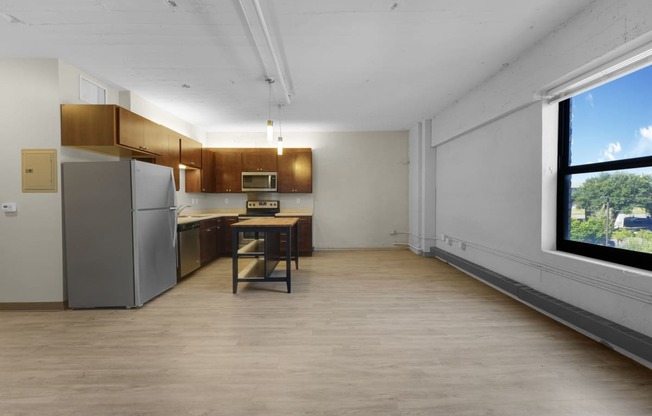 a kitchen with a refrigerator freezer next to a window