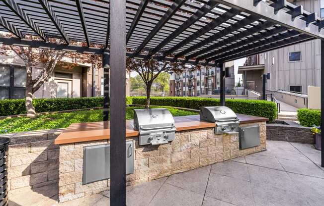 bbq area with a stone wall and a pergola