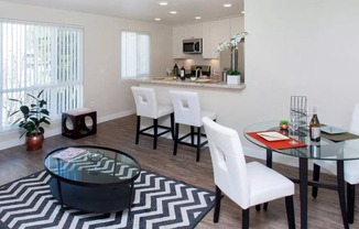 a living room with a table and chairs and a kitchen