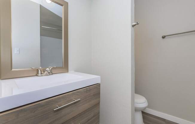 a bathroom with a sink mirror and toilet in a 555 waverly unit